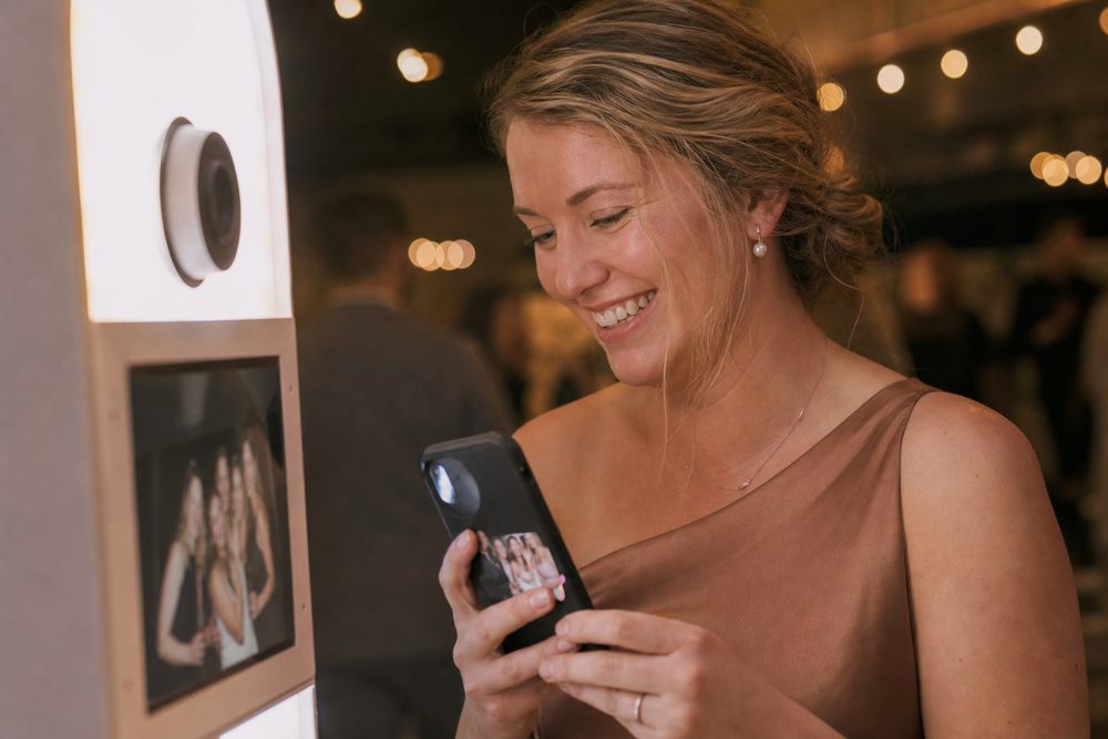A guest looking at her photo booth photo on her phone